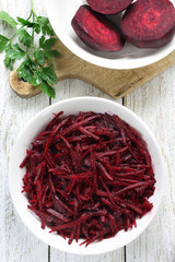 Grated red beets in bowl