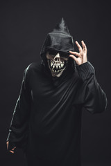 skeleton in a black robe holds sunglasses
