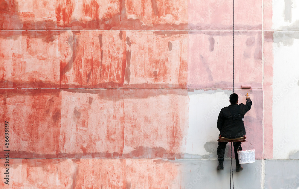 Wall mural Painter works on the outer building wall