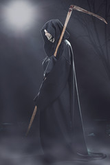 death with scythe standing at night