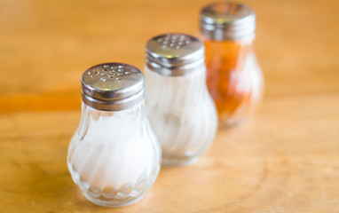 salt and pepper in shaker glass bottle on wood table