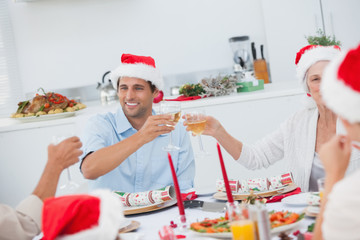 Happy family clinking their glasses of white wine