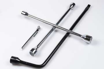 Lug wrench, tire iron and tire pressure gauge on white