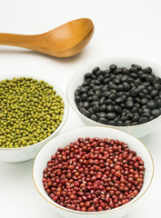 variety beans in bowls with wooden tablespoon