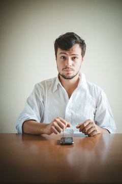 young stylish man with white shirt on the phone
