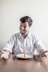 young stylish man with white shirt eating carrot