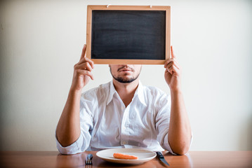 young stylish man with white shirt holding blackboard