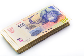 Scattered pile of bundled south african rand bank notes on an is