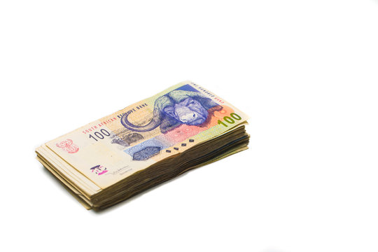 Scattered pile of bundled south african rand bank notes