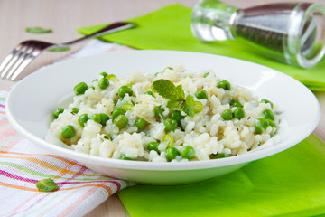 Italian risotto with rice, green peas, mint and cheese