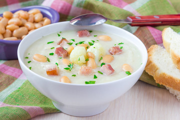 Cream soup with cauliflower, white beans and fried bacon