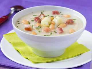 Cream soup with cauliflower, white beans and fried bacon