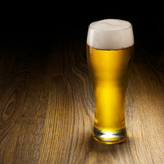 Glass beer on wood background with copyspace