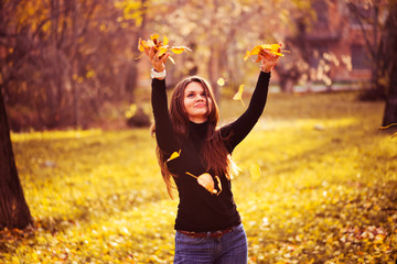 young woman throwing leaves woman in the forest