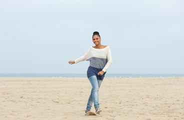 Happy young woman enjoying a walk on the beach