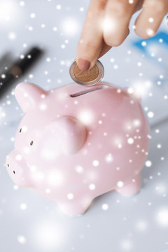 Woman Hand Putting Coin Into Small Piggy Ban