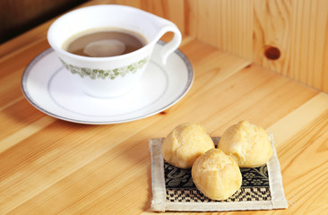 Bread Eclair with coffee on the wooden