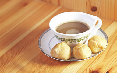 Bread Eclair with coffee on the wooden