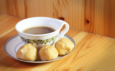 Bread Eclair with coffee on the wooden