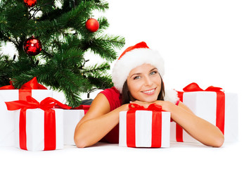 Obraz na płótnie Canvas smiling woman in santa helper hat with gift boxes