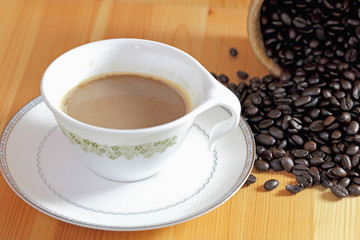 Coffee cup and coffee bean on a wooden table