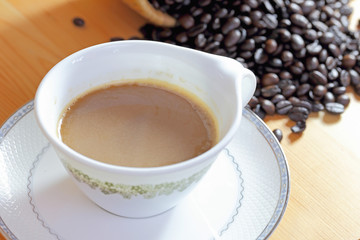 Coffee cup and coffee bean on a wooden table