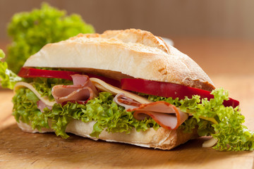 Tasty sandwiches with vegetables on a wooden table.