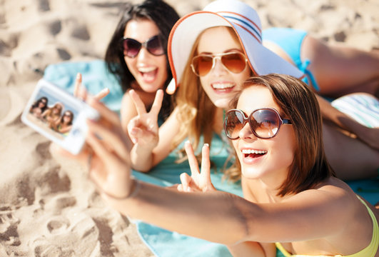 girls taking self photo on the beach