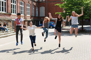 fröhliche Schüler springen draußen