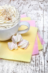 hot chocolate with marshmallows and cream on wooden background