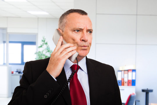 Perplexed businessman talking on the phone