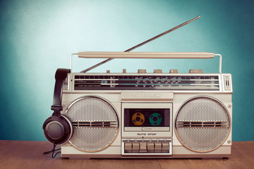 Retro cassette ghetto blaster and phones on table