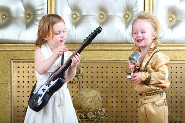 A little girl plays guitar and pop musician sings song