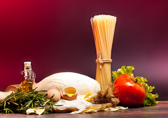 ingredients for homemade pasta on wooden table on brown backgrou