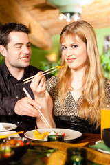 Young people eating in Thai restaurant