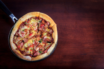 delicious pizza in pan on wooden background