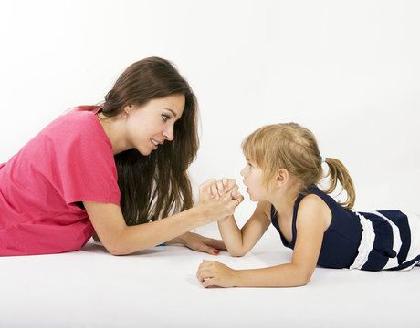 mother and daughter arm wrestling (difficult parenting)