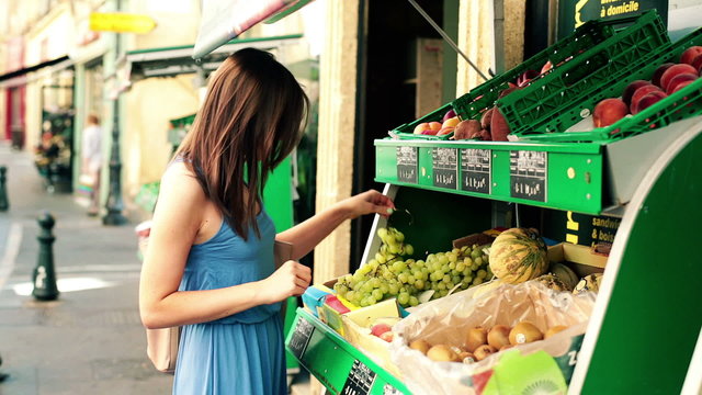 Woman on shopping looking at fruits, vegetables in shop