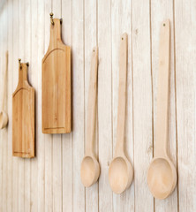 cutting boards and wooden spoons hanging on the wall, kitchen ut