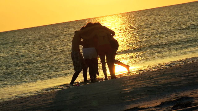 Young College Friends Enjoying Weekend Break Beach Sunset