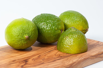 Limes on a wooden table, isolated on white