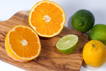 Fototapeta na wymiar Limes, lemon, orange and tangerine on a wooden table, isolated