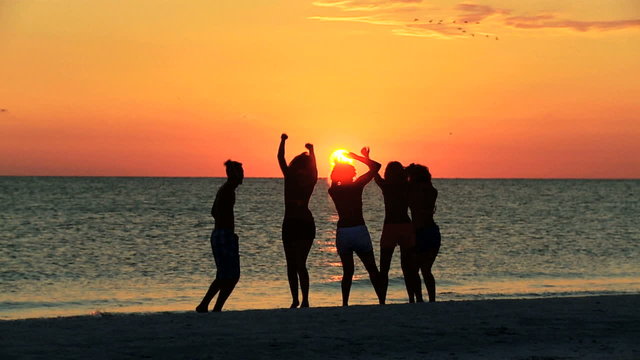 Silhouetted College Friends Laughing Dancing Beach
