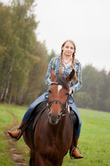 Obraz premium A girl rides a horse on the field