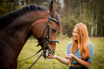 Obraz premium The girl with red hair and a white horse