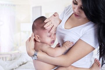 Fototapeta na wymiar Asian mother checking her daughter's fever