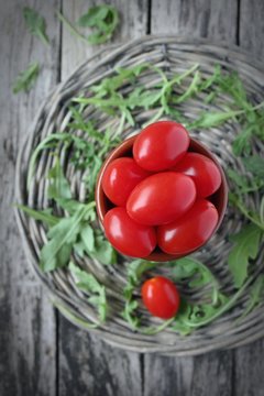 Cherry tomatos on wooden background (vignette)