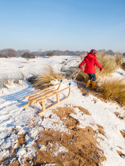 small girl  with a wooden sledge
