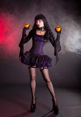 Beautiful witch in purple and black gothic Halloween costume