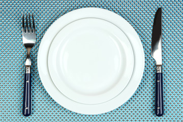 Knife, color plate and fork, on color background